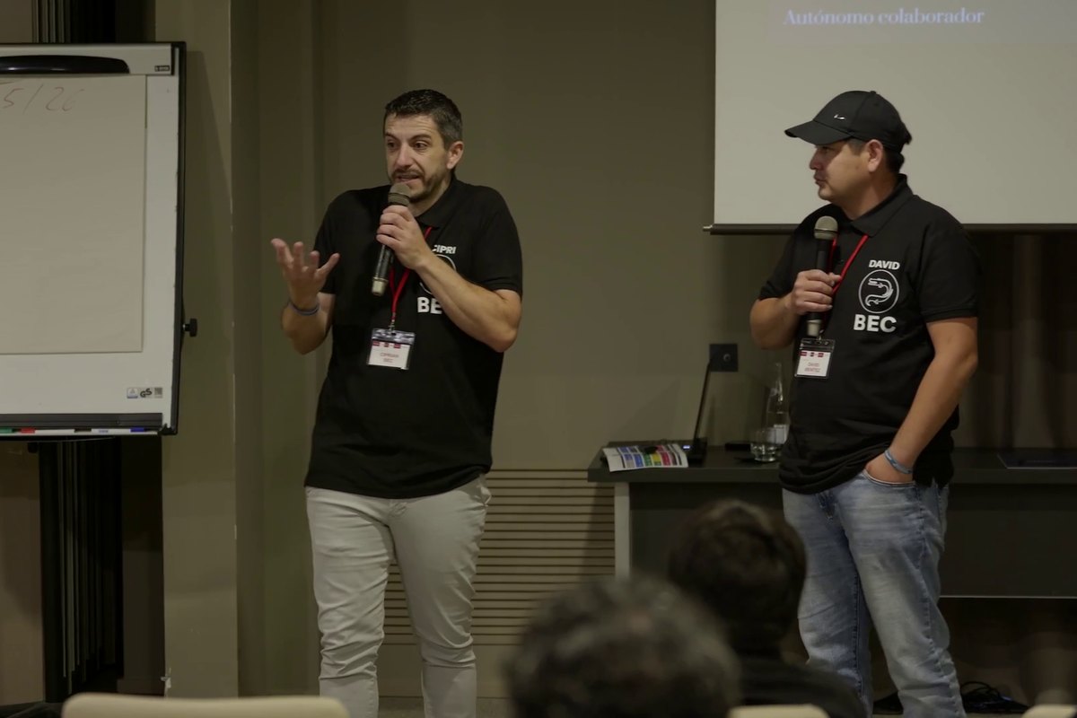 Cipri y otra persona del equipo con micrófono en el escenario, durante una intervención